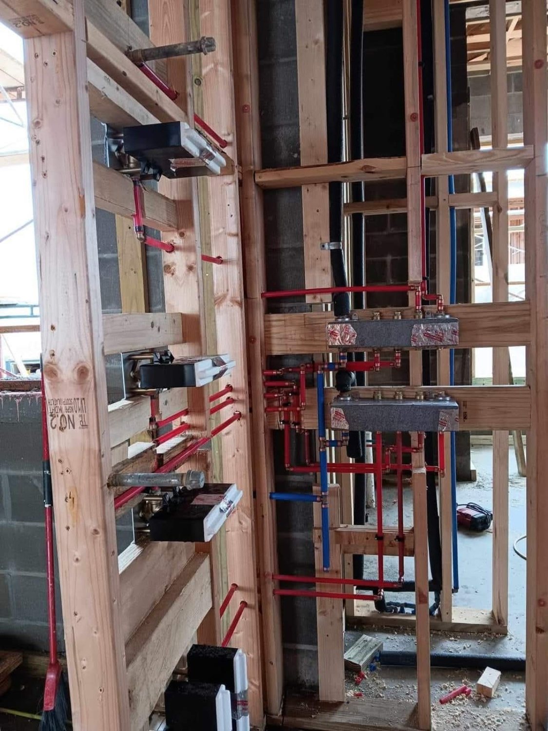 Red and blue plumbing supply rough-in inside framed building