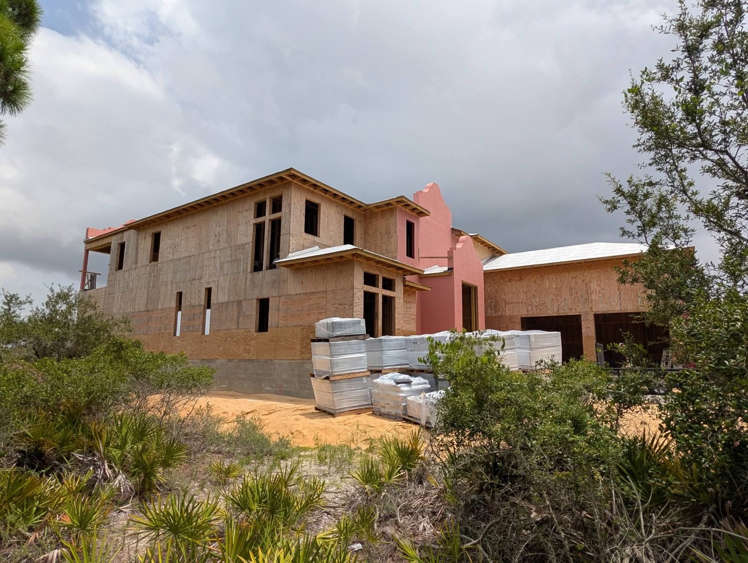 Large custom home under construction with framing and sheathing